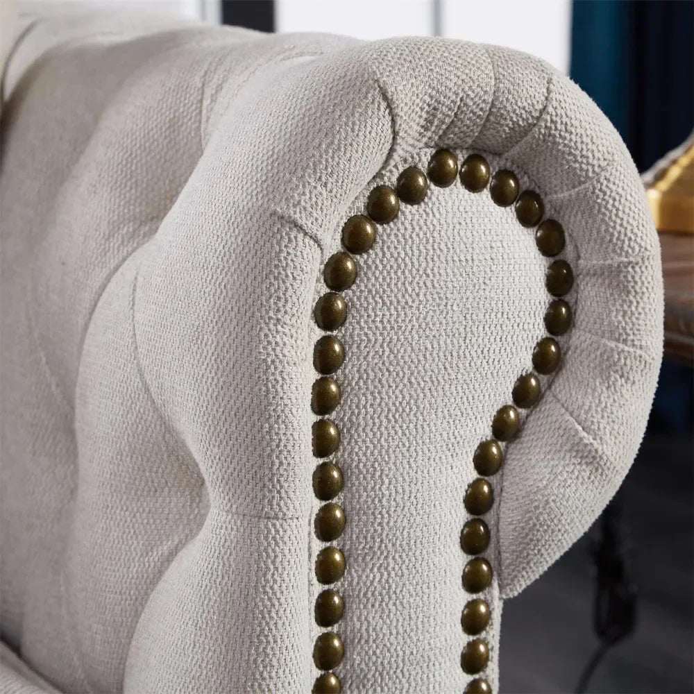 Close-up of a 3-Seat Chesterfield Sofa by Morsale, featuring a beige, textured fabric arm with decorative brass nailhead trim. The blurred background emphasizes the detailed upholstery, making this modern sofa a standout piece in any living room.