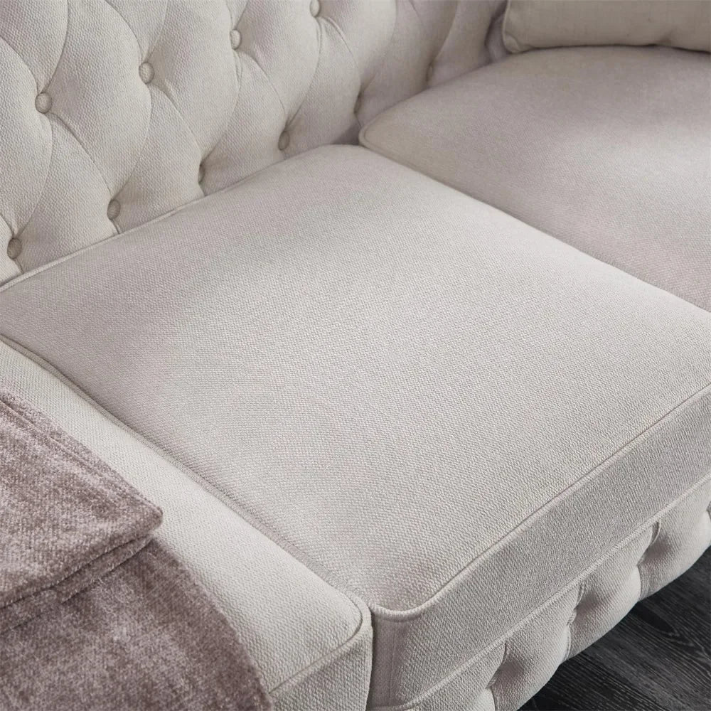Close-up of Morsale's 3-Seat Chesterfield Sofa featuring gray tufted design and cushion seating. A folded gray blanket on the left armrest complements its fabric texture and button details, making it a stylish addition to any living room on a dark wooden floor.