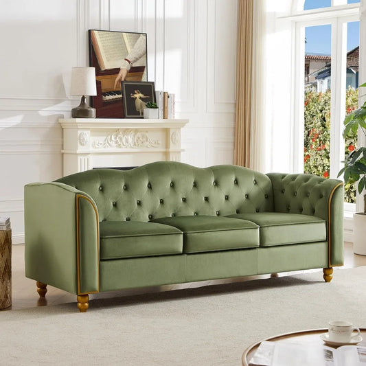 A green, tufted Morsale 3-Seater Living Room Sofa Couch with wooden legs adorns a bright, minimalist space with white walls. Behind it, an elegant mantel displays decor. Large windows flood the room with light, offering a stunning garden view.