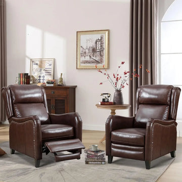 A cozy living room features two Morsale's Chester Genuine Leather Recliner Chairs, one elegantly reclined. A round wooden table with red flowers sits between them, a framed picture adorns the wall, and a wooden cabinet in the background showcases charming decor items.