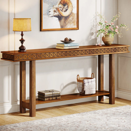 The Stanton Entryway Table With Storage by Morsale stands against a geometric-patterned wall, adorned with a lamp, books, and a vase of flowers. Below, a woven basket and more books sit on the lower shelf. A framed ram picture hangs above in this stylish piece of living room furniture with light walls and wooden flooring.