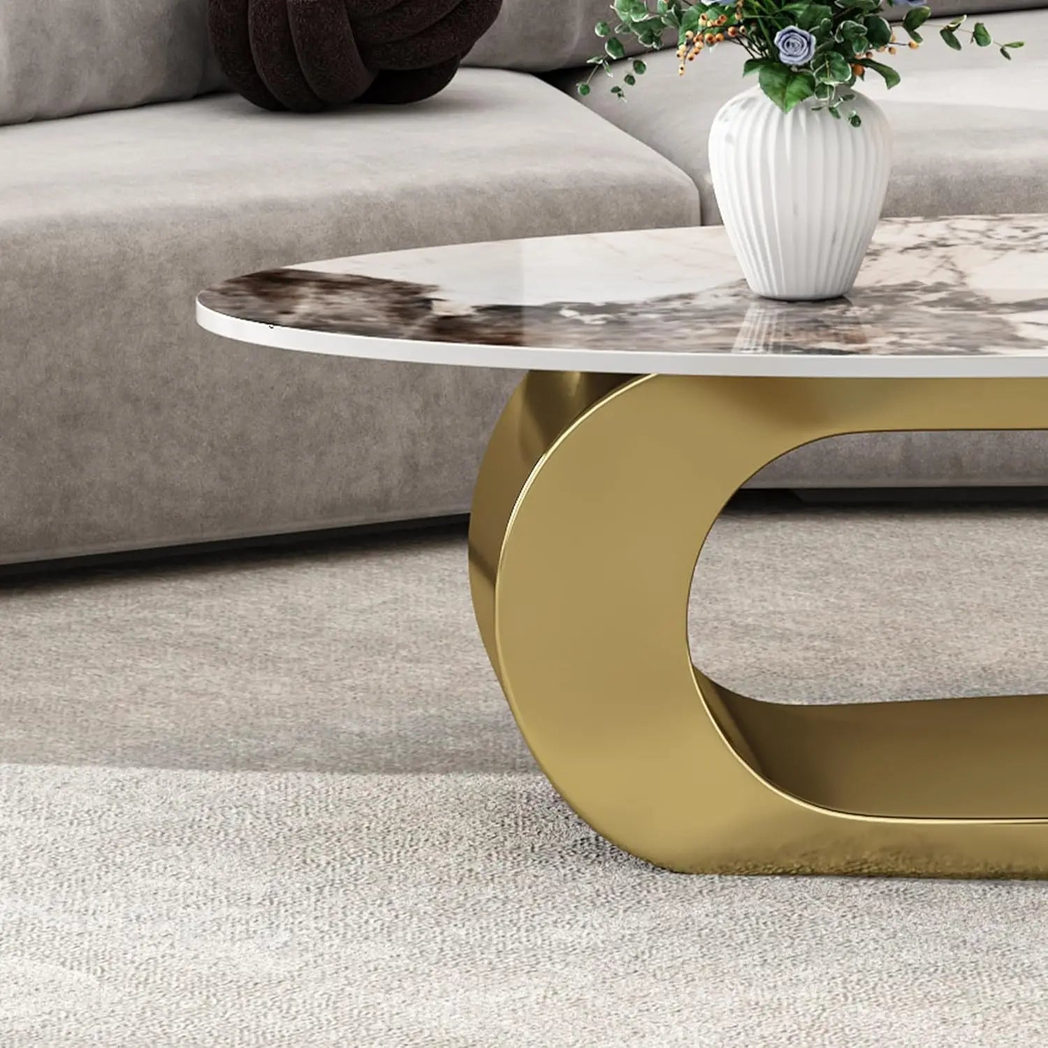 On a beige carpet sits Morsale's Modern Coffee Table, which features a ceramic top and durable steel base. Adorning the table is a white vase filled with green foliage and purple flowers. In the background, a gray sofa is enhanced by a dark decorative pillow.