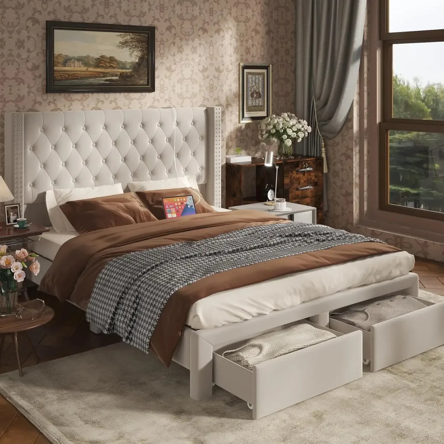 A cozy, modern bedroom showcases the Morsale Gio Velvet Queen Bed with a large tufted headboard and brown checkered cotton bedding. Open storage at the foot reveals blankets, while a nightstand with flowers, curtained window, and framed art complete the decor.