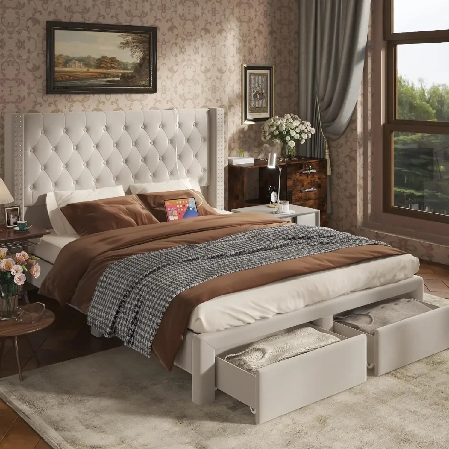 A cozy, modern bedroom showcases the Morsale Gio Velvet Queen Bed with a large tufted headboard and brown checkered cotton bedding. Open storage at the foot reveals blankets, while a nightstand with flowers, curtained window, and framed art complete the decor.
