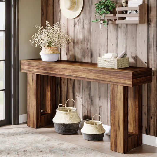 The Morsale Farmhouse 63-Inch Entryway Console Table against a wood-paneled wall evokes retro nostalgia, adorned with a basket of white flowers and a small woven basket. Two antique-style baskets are below, while above hang a plant and straw hat. A tasteful rug covers the tiled floor.