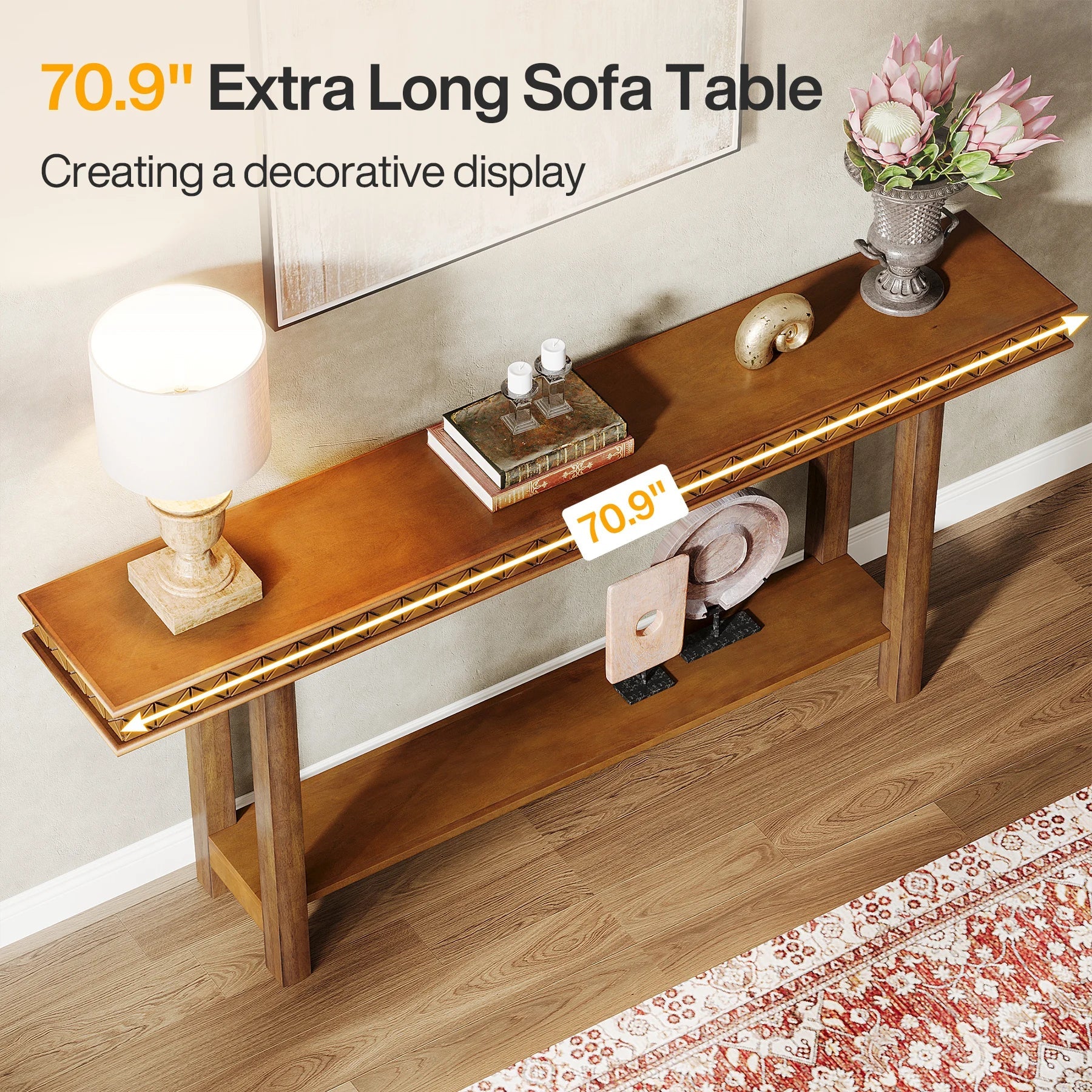 The Morsale Stanton Entryway Table With Storage is a modern wooden console featuring a lamp, books, flower vase, and sculpture. At 70.9 inches long with under-shelf storage, it’s perfect for enhancing your living room’s decor on a patterned rug.