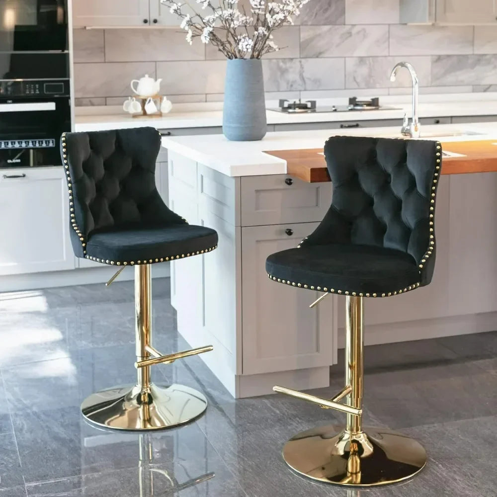 In the modern kitchen, a set of two elegant Morsale Counter Height Swivel Bar Stools with ergonomic tufted white upholstery and gold bases enhances the space. They offer adjustable height swivel function and complement the gray cabinets, marble backsplash, and central island with white flower vase.