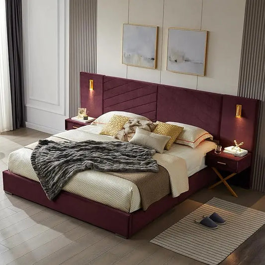 A bedroom features a Morsale King Size Bed with lighting and bedside tables, showcasing a velvet upholstered burgundy headboard. Cream, beige, and gray bedding is complemented by a textured throw. Two abstract paintings hang above, with wall-mounted lights illuminating the scene. Nearby rest slippers.