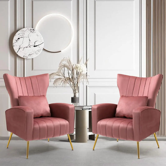 Two Morsale Modern Velvet Lounge Chairs, featuring gold metal legs and a pink hue, are symmetrically placed in a chic room. A small table with a vase of dried flowers sits between them. The wall features vertical lines and a circular art piece with halo lighting above.