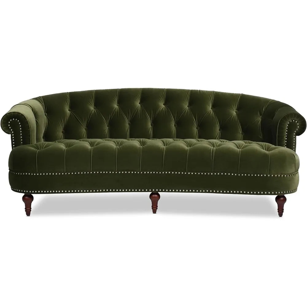 A living room includes a Chesterfield Velvet Tufted Sofa in Olive Green by Morsale, a round wooden coffee table, two side tables with matching lamps, and is adorned with a neutral striped rug. A textured abstract art piece enhances the elegance of the light-colored walls.