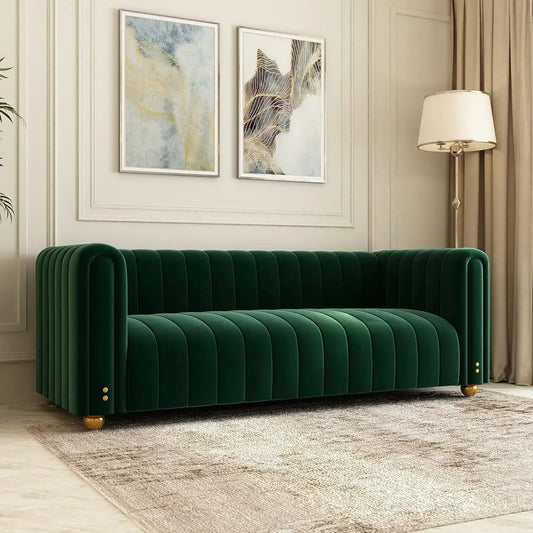 An 80" Velvet Living Room Sofa by Morsale, with a Chesterfield-style and tufted design, graces a well-decorated living room. Two abstract paintings hang above it. A nearby tall floor lamp adds warmth, light curtains frame the window, and a textured rug completes the elegant setting.