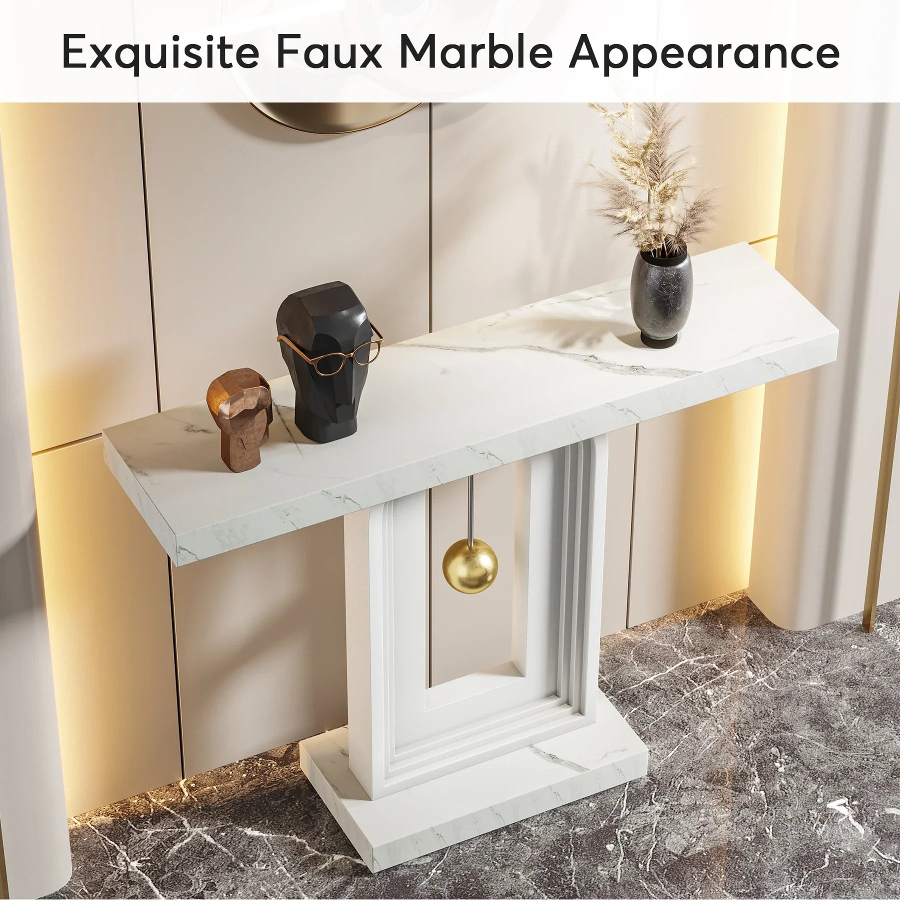 The Westford Contemporary Entryway Table by Morsale, featuring a faux marble top, showcases two abstract sculptures and a vase with dried flowers. Set against a textured wall with warm lighting, this scene exudes a minimalist modern elegance.