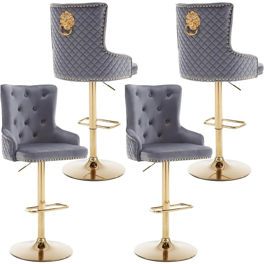 Morsale's Diamond Lattice Wingback Counter Stools elegantly accompany a marble-topped counter with quilted gray upholstery and gold bases. One stool has a lion emblem, enhancing the minimalist room's modern charm, featuring dark walls and a light floor.